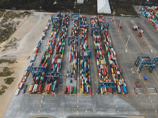 Aerial drone photo of colorful transport 20 and 40 feet containers stacked in container terminal.  