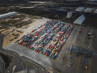 Aerial drone photo of colorful transport 20 and 40 feet containers stacked in container terminal.  