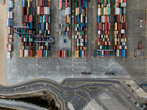 Aerial drone photo of colorful transport 20 and 40 feet containers stacked in container terminal.  Top down view.