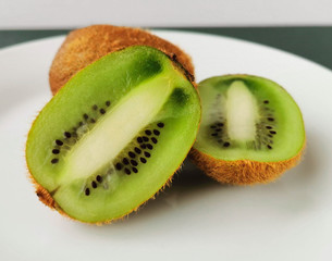 Halves of fresh kiwi are on a plate
