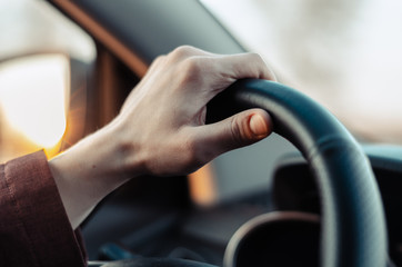 Closeup guy hand on car steering wheel