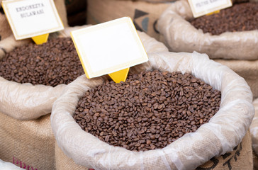 Raw coffee grains in sacks close up.
