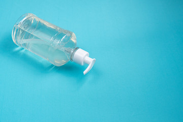 Container with alcohol gel on the light blue background