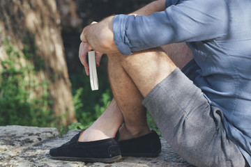 Man reading book outside. man sitting in park with a book close up