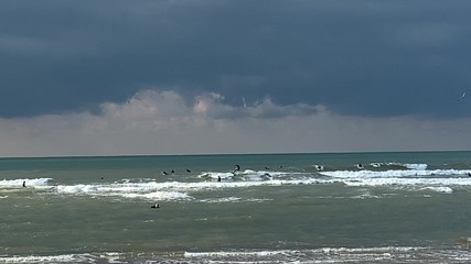 Surfing at stormy sea on dark blue cloudy sky background . 4K