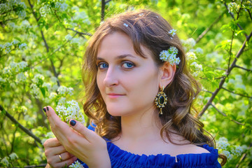 Girl with a branch of cherry blossoms in her hands