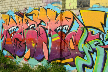 Abstract colorful fragment of graffiti paintings on old brick wall. Street art composition with...