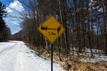 Chelsea road sign  for cars  distance between cyclists and car in April Gatineau park Quebec Canada