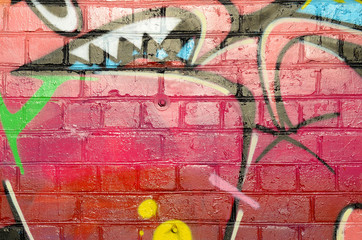 Abstract colorful fragment of graffiti paintings on old brick wall. Street art composition with...