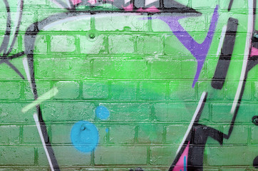 Abstract colorful fragment of graffiti paintings on old brick wall in pink and green colors. Street...