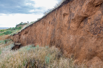 layers of earth with cracks due to landslides of the soil ecological disaster in outdoor clay wall...