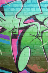 Abstract colorful fragment of graffiti paintings on old brick wall in green colors. Street art...