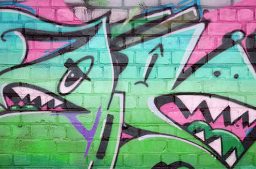 Abstract colorful fragment of graffiti paintings on old brick wall in green colors. Street art...