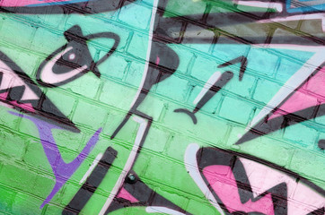 Abstract colorful fragment of graffiti paintings on old brick wall in pink and green colors. Street...