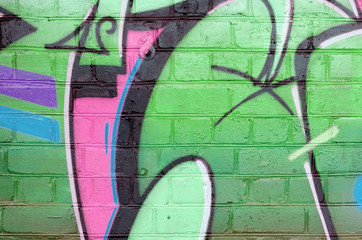 Abstract colorful fragment of graffiti paintings on old brick wall in green colors. Street art...