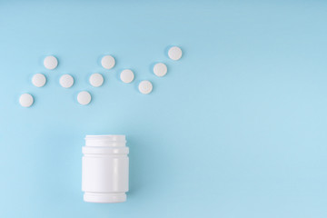 Cardiogram sign, heartbeat symbol from pharmaceutical medicine pills. Creative layout of tablets and bottle on blue. Medicine; healthcare concept. Copy space; flat lay