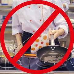 The chef prepares food and roasts it in a frying pan in the large kitchen of the cafe. Quarantine...