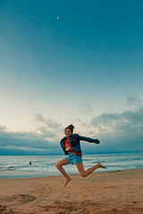 Fototapeta na wymiar mujer joven saltando en la playa