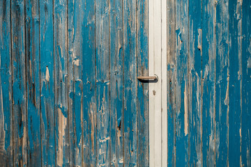Lack blättert ab von altem blauen Holztor