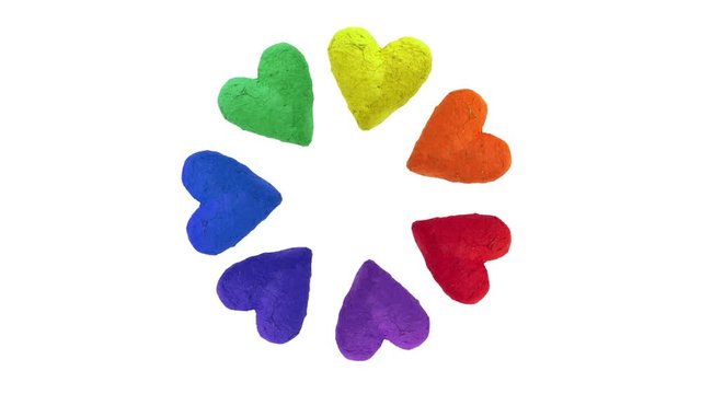 Rainbow color hearts from handmade dyed paper turning in circular motion. White background.
