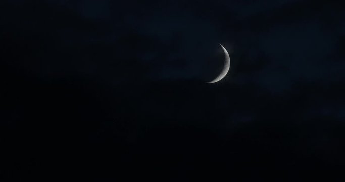 Crescent Moon With Clouds That Are Blown By The Wind During A Storm At Night Clouds Float Past The Moon. On The Surface  You Can See Details Of The Moon On A Dark Cloudy Night