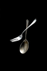 Antique silver spoon and fork on black