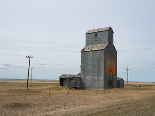Fototapeta na wymiar Metal Montana Grain Elevator in a prairie with power poles.