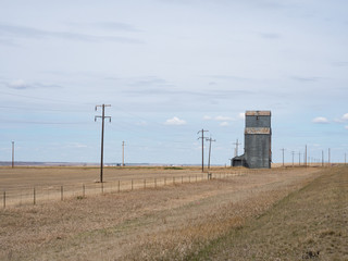 Fototapeta na wymiar Metal Sided Grain Elevator in Rural Montana with power poles and field in the foreground.