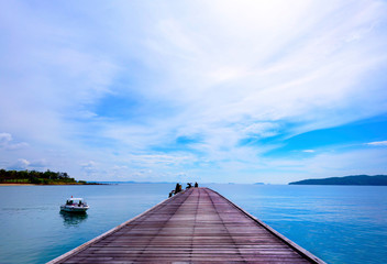 A wooden bridge that stands in the sea and has a beautiful sky and a boat parked next to the bridge, Beauty of nature concept, Landscapes, Old wooden bridge, The day the sky was brightม Speed boat