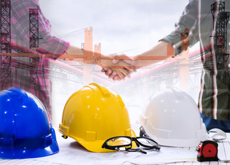 Safety first background, Yellow helmet and blue helmet and white helmet and goggles are on the table and there is a measuring tape in front, Handshake background, Safety induction, Safety glasses