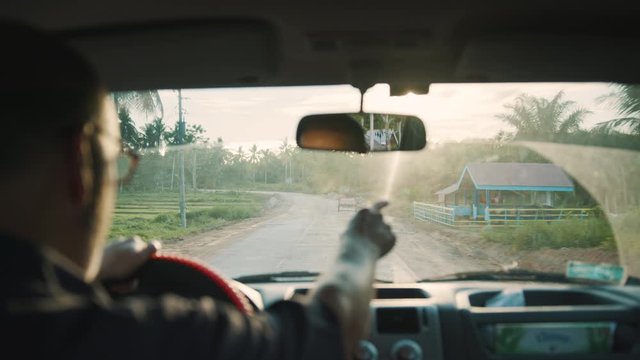 Man In Car Driving On Dirt Road In Poor Third World Country