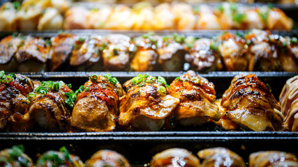 Close up hand of Japanese chef using kitchen torch burn sushi