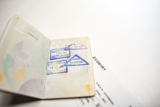 immigration stamps on passport and Thai passport with Plane economy ticket background.