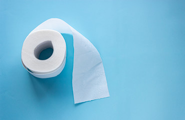 roll of white toilet paper on blue background layout. copy space text. banner hygiene supplies concept 