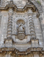 A statue, flanked by solomonic columns on the front of Guadalajara's Templo de San Francisco de Asis, a colonial church built between 1668 and 1692.