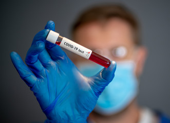 Scientist testing coronavirus positive blood sample researching for COVID-19 antibodies and vaccine