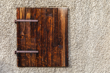 Classic aged wooden window on rough wall.