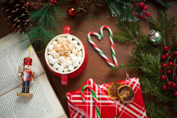 Hot chocolate surrounded by christmas items and tree