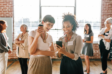 Female coworkers looking at a smartphone