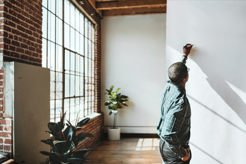 Man writing on an empty white poster