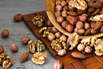 Almonds, walnuts and hazelnuts. Without shell. On a gray wooden table.