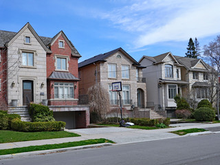 Suburban street with large detached houses with gables