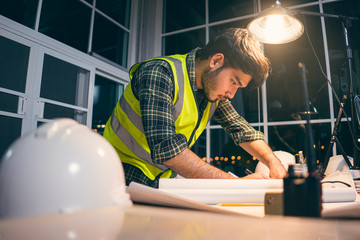 Contractor worker over time working in office,
A man hard working at home office on the night.