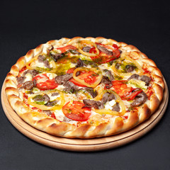 Delicious pizza served on a wooden plate isolated on black