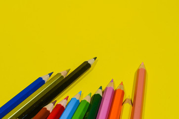 wood colored pencils on a yellow background and have copy space. Color pencil concept
