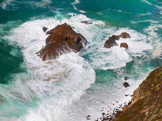 waves crashing on rocks top view from sea coast