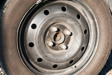 An old car tire wheel without metal cover