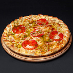 Delicious pizza served on a wooden plate isolated on black