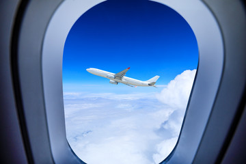 Looking at airplane flying above clouds from airplane window,travel concept.