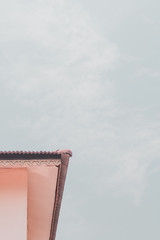 The roof of a home  on a minimalistic sky background.